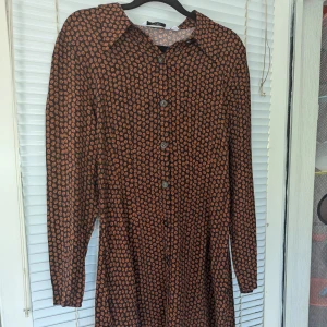 & Other Stories Mimiklänning i brunt mönster,strl 40/ 100% viskos  - Material och mått: Tunt och luftigt material, vilket ger ett skönt och lättburet plagg. Byst: 40 cm Midja: 43 cm Längd: 90 cm Upptagen: 38 cm Axel till axel: 41 cm Färg: Brun med mönster Antydan till slitage på ytan,i mycket fint skick 