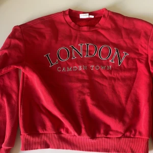 En röd tjocktröja med text - En röd tjock tröja med texten london camden town, den är ungefär 2 år gammal och jag säljer den för att den är förliten för mig