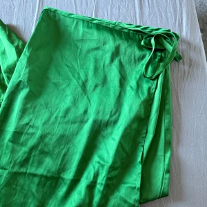Långkjol - En jättefin kjol i en helt perfekt grön färg. Den går om lott och knyts på sidan vilket skapar en slits fram. Är från bikbok i stl s, 50kr💚