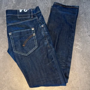 DonDup jeans - Ett par riktigt feta och stilrena jeans från DonDup i mörkblå med en slitning på vänster knä. Riktigt fint skick✅Storlek 34 men sitter mer som 32. Tveka inte att höra av er om ni har några funderingar! 🌳 