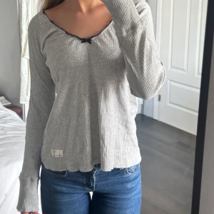 Oddmolly tröja - Säljer min älskade grå oddmolly tröja.💓Som har en fågel på armen och rosett vid halsen. 💘💘passar storlekarna S-L🫶🏼 Skriv för fler bilder så löser jag det!