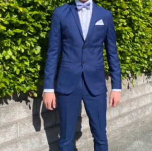 Jack & Jones kostym  - Jack & Jones blå kostym strl 44/46 Jättefin blå kostym i storlek 44 på kavajen slim fit och 46 på byxorna. Passar kille ca 175-182 cm lång. Använd vid nians skolavslutning, enstaka tillfälle, jättefint skick & bra kvalitet. Nypris 1900kr 