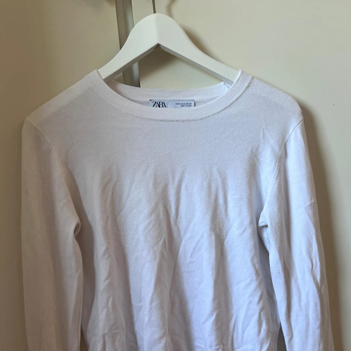 Vit tröja med guldiga knappar