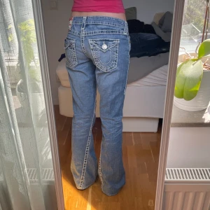 True religion jeans - Jätte snygga true religion jeans, dom är utsvängda och lågmidjade med tjocka vita sömmar. Midjemåttet är 39cm och innerbenslängden är 76cm. Skriv om du undrar något💗