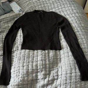 Svart stickad topp - Croppad svart långärmad tröja. Skönt material, köpt på brandy Melville👍 knappt använd.