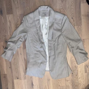 Beige kavaj - Beige kavaj från Hm i storlek 40 (liten i storleken). Kavajen har ”scrunchade” ärmar. Använd någon enstaka gång, knappt något tecken på det. 