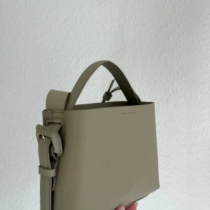 Väska arket inspirerad - Väska från H&M som är väldigt lik den från arket!  Den är dovt ljusgrön Använd en gång så den är i väldigt fint skick. Kan mötas upp i centrala Sthlm/bromma eller frakta men då står köparen för frakt 🥰 