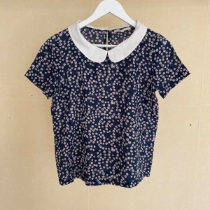 Blommig blus från Maje - Maje “E12LOUETTE”- Maje- En blommig blus , storlek small. Den är, ja synonym till söt. 100 bomull, en tunn, luftig kvalite. 100% sommar, Färgen är genomgripande mörkblå med ett mönster av små vita/ rosa blommor. Mest utmärkande, kanske, är den  distinkt  kragen, mycket, a la fransyska   -Material: 100% cotton -Size: 1/Small Measures- Length: 56cm Shoulders: 38cm Chest: 48cm Waist: 48cm Sleeves: “over” 19cm, “under” 6cm -Condition: Very good  #maje #parischic #floraltop