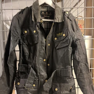 Barbour jacka - Superfin oljerock från Barbour. Storlek 32/XXS men passar XS också. Använd men väldigt bra kvalitet så inga tydliga defekter.