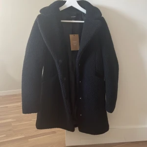 Kappa - Svart halvlång TeddyKappa från VeroModa. Helt oanvänd med prislappen kvar. Nypris 650kr säljer för 350kr