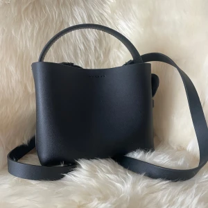 Arket väska  - Hej säljer denna Arket väska åt min syrra då hon inte använder den längre ny skick och använd sparsamt  Modell crossbody väska lilla modellen ny pris 1400 köpt på deras hemsida 