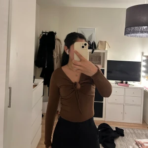 Topp med knyte  - Brun topp med snörning vid brösten (justerbar) från Bik Bok. Använd fåtal gånger. Typ lite mesh material.