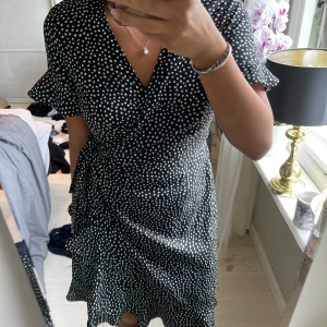 Klänning - Svart prickig klänning med knyt från Vera Moda!