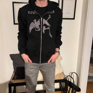 En riktigt snygga reinstone hoodie från Cosanostra den är väldigt limiterad då det bara såldes ett fåtal par av den modellen och nu säljs den inte längre. Storleken är S och tröjan är i nyskick. Hör av er vid frågor eller funderingar!