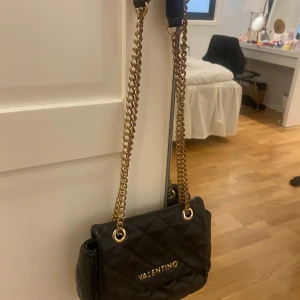 Valentino väska - Jätte fin valentino väska. Äkta såklart köpt för ca två år sen inte använd på ett tag därför jag tänker sälja. Inga defekter men kedjan är lite rostig. Men jätte fin. Den har guldetaljer. Kom med bud.