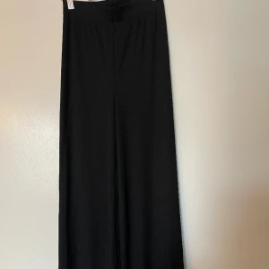 Svarta byxor  - Svarta byxor som är wide och sitter perfekt vid midjan. Den är bekväm och snygg och perfekt för sommaren. Har haft den typ en gång så den är helt ny. 