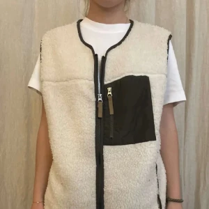 Teddyväst  - Teddy väst med mörkgröna detaljer! Använd gärna köp nu