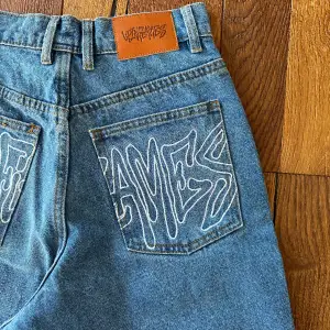 Up in Flames Ldn  Unisex Baggy jeans., köpta från drop i oktober, limited edition, aldrig använda. Stl unisex xs motsvarar ca stl 26 Instagram: UpInFlames  Mått Wasit 68 cm Inseam 74 cm Outside 100 cm Waist to crotch 32 cm