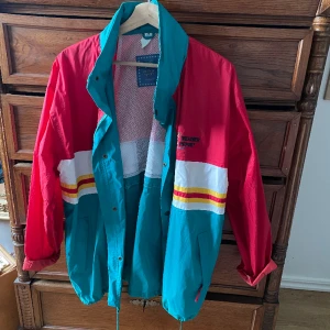 Regnjacka  - Vintage regnjacka, dragkedjan är trasig men går fortfarande att knäppa hela vägen, annars finns knappar. Inbyggd luva i kragen!!