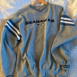 Seahawks sweatshirt  - Så snygg sweatshirt med Seattle Seahawks logga på. Tjockt och härligt tyg och så bra passform! Står ingen storlek i men gissningsvis en herr L🩷 sitter overzised på mig som bär s! 
