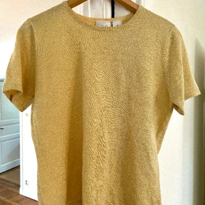 Guldig stickad t-shirt💛 - Finstickad t-shirt med glitter guld!! Tröjan sticker inte och hade egentligen tänkt ge den till en kompis så den är oanvänd. Köpte originellt på second hand för 190💞