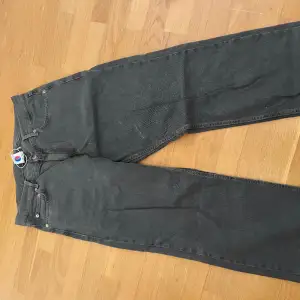 Mörk gråa baggy jeans med detalj på bakre fickan