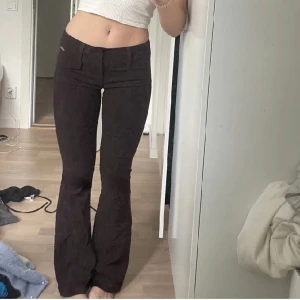 Bruna kostymbyxor  - Bruna Urban kostymbyxor som är utsvängda i modellen och har en jättefin passform. 