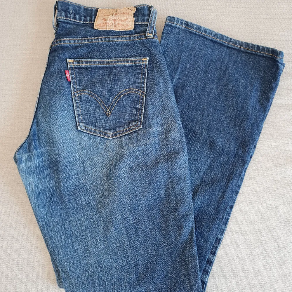 Levi's jeans i bootcut modell och low waist. I ganska slitet skick. Mindre hål finns (se bild 3). Står att de är i storlek 30x32 men skulle mer säga att de passar dig som är mellan XS och S, jag mäter omkretsmåttet till ca 82 cm! . Jeans & Byxor.