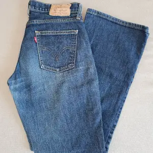 Levi's jeans i bootcut modell och low waist. I ganska slitet skick. Mindre hål finns (se bild 3). Står att de är i storlek 30x32 men skulle mer säga att de passar dig som är mellan XS och S, jag mäter omkretsmåttet till ca 82 cm! 