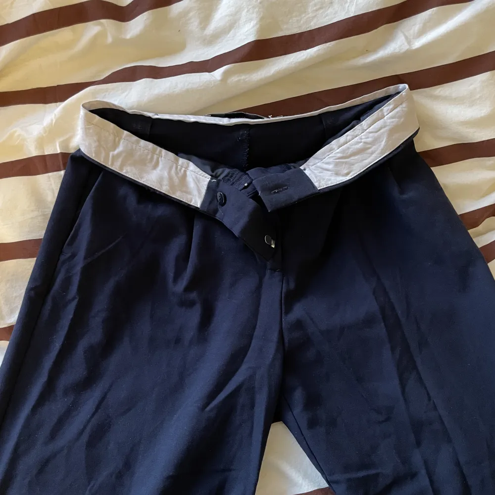 Marinblå kostymbyxor från Bershka. Kan bli low waist om man viker ner kanten (blir snyggt med det vita då också). Strl 34 men skulle nog säga mer åt 36! Köparen står för frakten💌 . Jeans & Byxor.