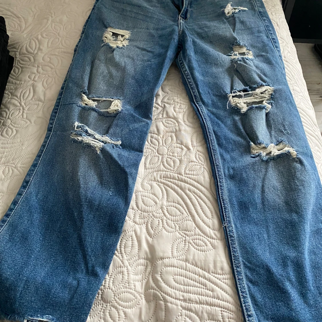 Blå jeans med slitningar