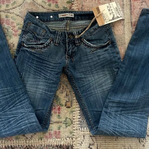 Lågmidjade vintage jeans💗💗 - Lågmidjade vintage jeans från märket the queen💗 Helt nya med lappar kvar💗 Midjemått:33cm innerben:82cm💖 (Obs, dragkedjan har hoppat ur dock borde det gå att få i den, dock inget som syns när d är på, kan skicka bilder på det om man vill)💖