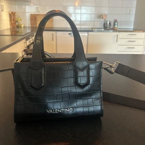 Valentino väska  - Som ny, medelstor väska. Svart skinn, med guldiga detaljer. 