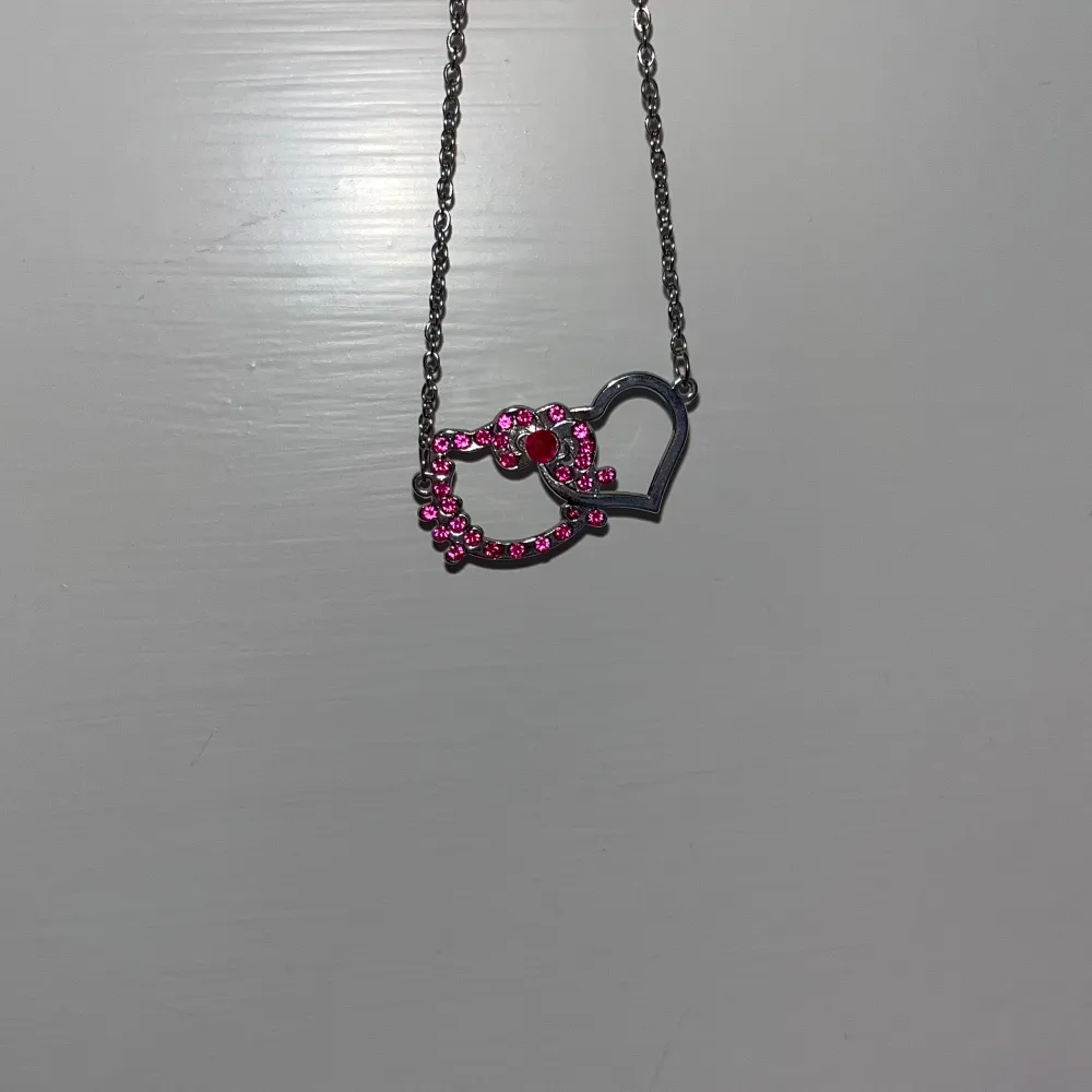 Jättefint hello kitty halsband från sanrio, saknar INGA av de rosa kristallerna, minimalt använd med jättefin silvrig kedja!!💗💗😻. Accessoarer.