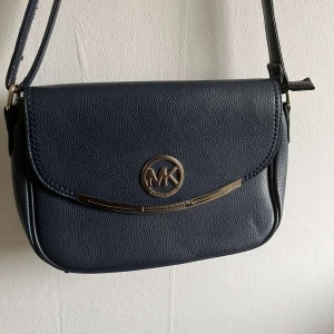 Blå Michael kors väska - Köpte på second hand. Använd men i bra skick. Enda defekten är det som syns på bild 4.