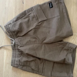 Bruna Cargoshorts - Oanvända bruna cargoshorts från asos. Stl xs