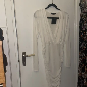 Vit klänning  - Helt oanvänd vit smått glittrig klänning. Prislappen sitter kvar. Köpt på Nelly för att ha på studenten men bestämde mig för en annan klänning i sista minuten. 