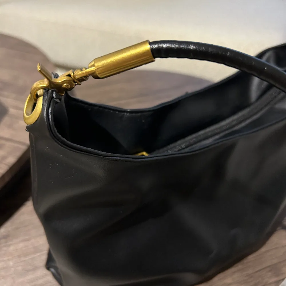 Säljer min svarta väska med guld detaljer, den är rymlig och lagom stor. Jätte snygg. Den är använd men inget ”skav” i fuskläderet. Den är i gott skick😁. Väskor.
