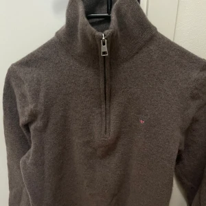 Gant tröja - En half zip tröja från Gant. Mycket bra skick , använd ett fåtal gånger. Skulle uppskatta kvaliten 9/10! Nypris ligger på ca 1200. Färg brun och storlek M ,men råkade torktumla den så passar S/XS. Fråga om ni undrar något eller vill ha fler bilder 😊