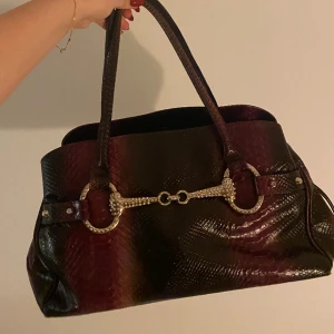 Äkta läderväska!💓 - Skitsnygg väska i älta läder med olika lila tomer i ett mönster och ett glittrigt spänne! Dator får plats!🙌perfekt till skola eller jobb!😌