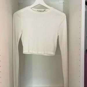 Ribbad topp - Ribbad vit topp. Är använd fåtal gånger och har inga defekter. Är från NA-KD. 