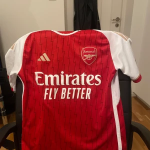 ANSENAL FOTBOLLSTRÖJA - Snygga färger snygg tröja köpt för 1000kr och säljs för 600 köpt i unisport i TC äkta fotbolls tröj står inget namn där bakom :)