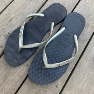 Havaianas flipflop - Säljer dessa silvriga och svarta flipflops från havaianas. De är i strl 39/40 och är i nyskick. Skriv vid frågor!!