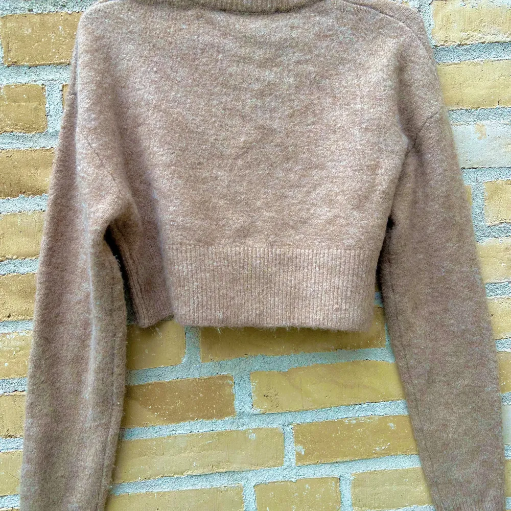 Stickad tröja från Zara. Kort modell. Beige. Storlek XS. Köpt i november. Använd men i bra skick. Någon noppa förekommer. Omfång byst: 104 cm. Längd: 42 cm.. Stickat.