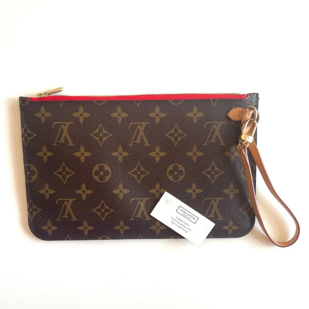 Säljer en äkta Neverfull clutch från Louis Vuitton. Väskan är i nyskick och en liten påse medföljer.   Bredd: 25 cm Längd: 15 cm. Väskor.