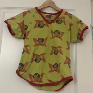 T-shirt - Cool ”retro” t-shirt med en massa änglatryck. Säljer då jag inte tyckte att den passade mig. 