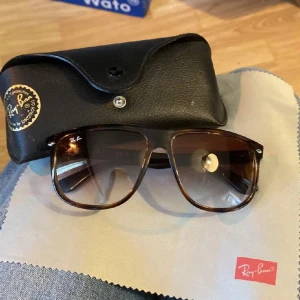 Solglasögon från Ray-Ban - Ett par solglasögon från Ray-Ban med modellnummer RB4147. Glasögonen har en brun färg och kommer med ett svart fodral och en putsduk.