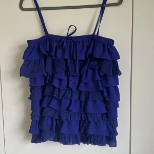 Volang topp - En blå volang topp från stella forest. Säljer då den inte kommer till användning.