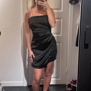 Svart miniklänning - Svart miniklänning från zara med glittriga detaljer. Har lite synliga tecken på användning men annars helt fin🤍