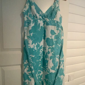 Oasis klänning( ny utan prislapp) - Oasis klänning i strl 10/36, superskick, köpt utomlands iår (Klänning med band för att knyta runt midjan)  Turkos/vit med turkosa pärlor Nypris ca500kr